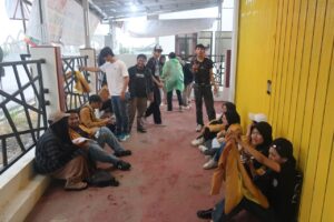 Massa aksi terlihat berteduh, menunggu hujan reda (25/09/2025) (beritaunsoed.com/Ryu Athallah Raihan)