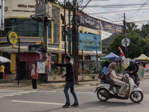 Slamet saat bertugas mengatur arus lalu lintas di simpang depan FIB (02/10/2025) (beritaunsoed.com/Helmalia Putri)