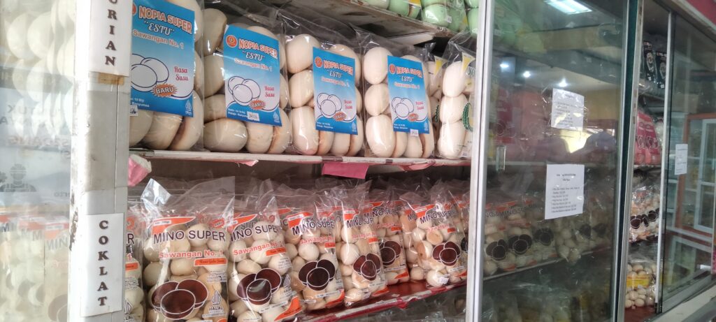 Kemasan produk nopia dan mino super legendaris pilihan konsumen yang tertata rapi di dalam rak kaca. (17/06/2026) (Beritaunsoed.com/Jeni Rindi Afriska)