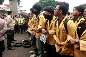 Massa aksi mengaitkan lengan satu sama lain untuk membuat barikade (13/6/2026) (Beritaunsoed.com/Artika Putri Kinanti)