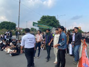 Koordinator lapangan, Pamungkas Handika, tampil mengenakan atribut pelamar kerja sebagai simbol tingginya kesulitan masyarakat dalam mencari pekerjaan (26/06/2026) (Beritaunsoed.com/Akhdan Maulana)